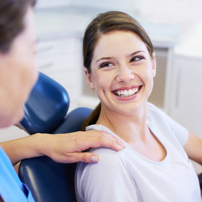 Woman in dental chair smiling at her Fort Worth dentist