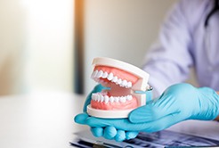 dentist holding removable dentures 