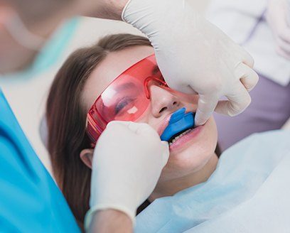 Young woman receiving fluoride treatment in dental office
