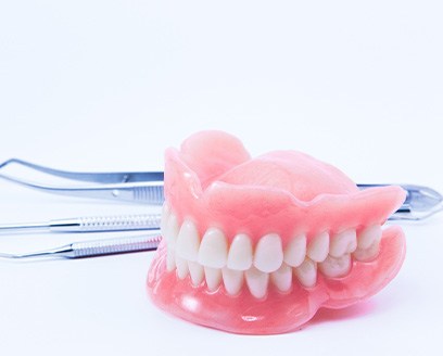 A pair of dentures and dental tools