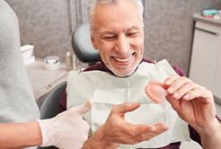 A man looking at dentures with a dentist