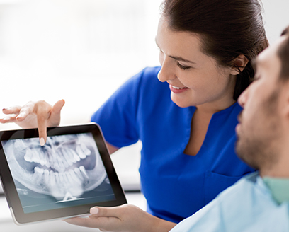 Dental team member showing patient x rays of teeth