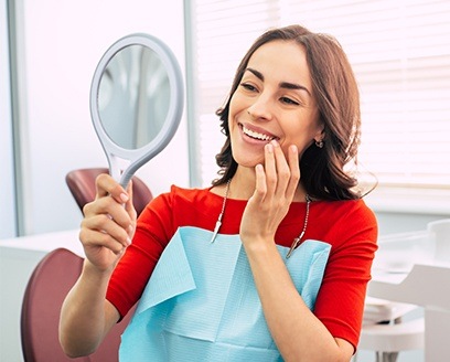 Dental patient looking at her smile in mirror