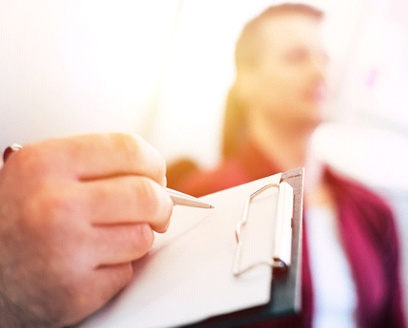 Dentist writing notes on clipboard