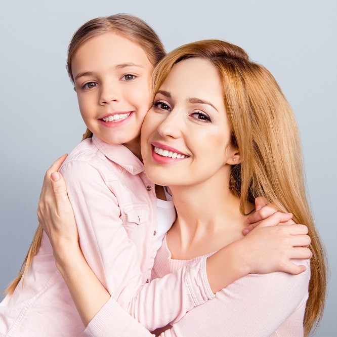 Smiling mother and daughter hugging after childrens dentistry in Fort Worth