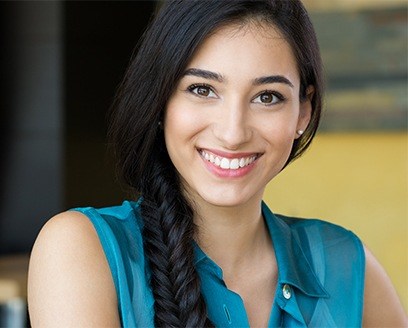 Young woman in sleeveless blue blouse smiling