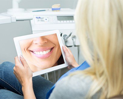 Woman looking at tablet showing future version of her smile