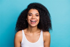 Woman smiling in front of turquoise background