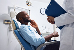 patient smiling while talking to dentist during exam