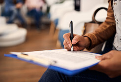 woman filling out dental insurance form in lobby