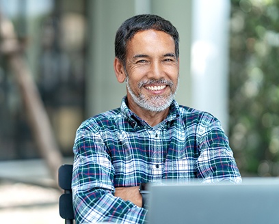 Older man in blue plaid shirt smiling