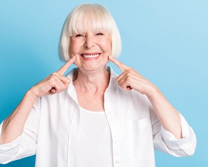 Senior woman pointing to her smile