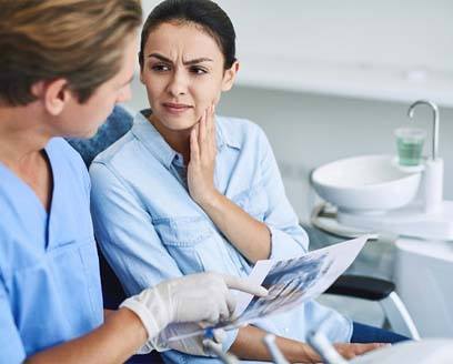 Woman talking to dentist about full mouth reconstruction