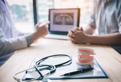 A patient consulting their dentist about dental implants 