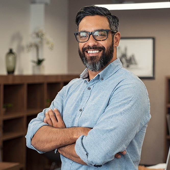 Man crossing his arms and smiling with dental implants in Fort Worth