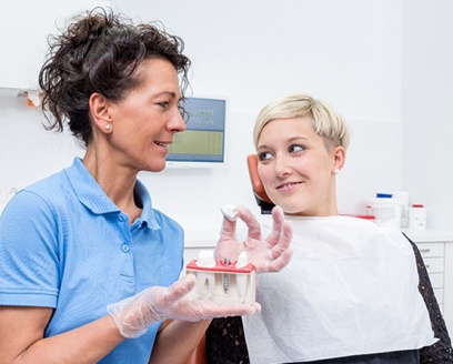 A female patient looking at her dentist while she explains how dental implants work