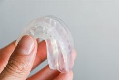 Patient holding up clear mouthguard
