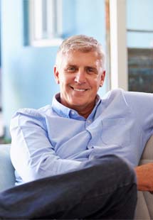 Older man smiling on couch