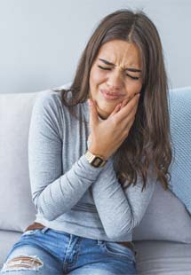 Woman holding her cheek in pain