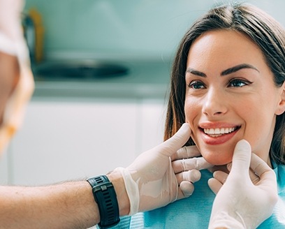 Fort Worth dentist looking at smile of woman after dental treatment