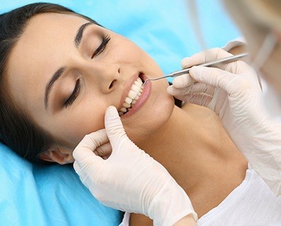 Woman receiving scaling and root planing from dentist