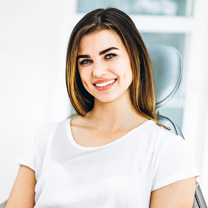 Smiling woman in dental chair for preventive dentistry appointment