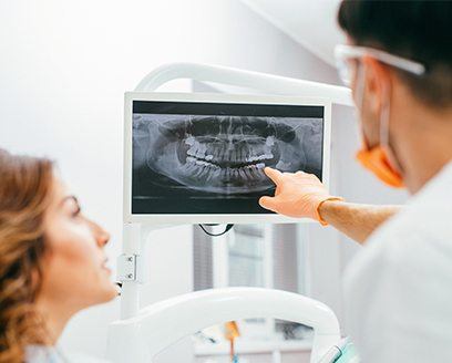 Dentist and patient looking at x rays of teeth
