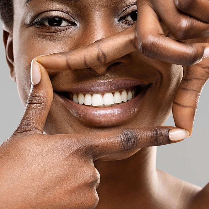 Person making frame around their smile with their fingers after teeth whitening in Fort Worth