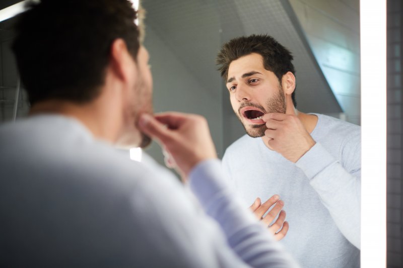 Man checking his loose tooth