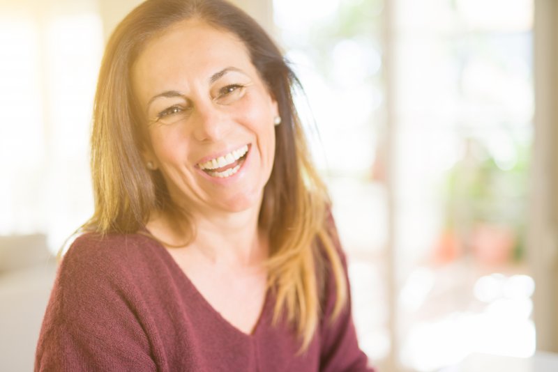 middle aged woman smiling with dental implants