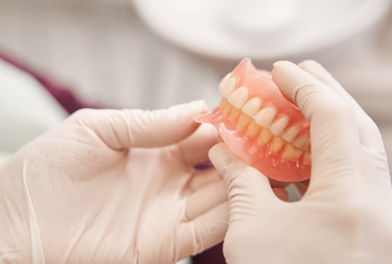 Dentist holding dentures