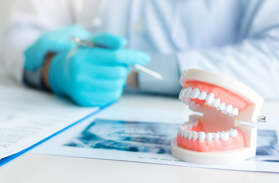 Dentures on a table with dentist's hand in background